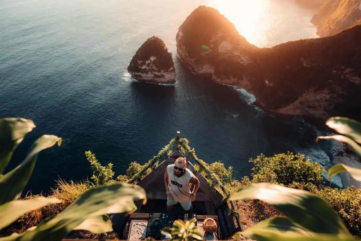 Tourist enjoying the breathtaking hidden viewpoint at Paluang Cliff overlooking the ocean, organized by Nusa Penida Transport Group